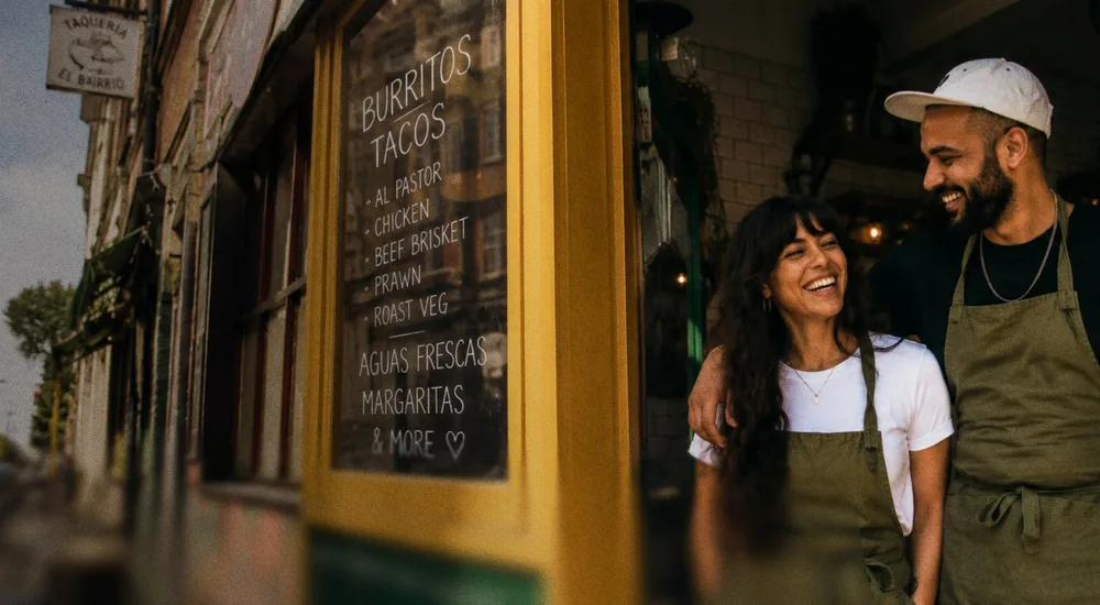 Deux restaurateurs souriants devant leur devanture