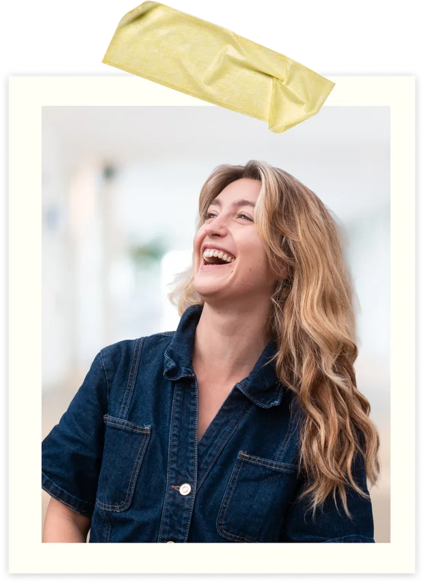 Iona, en veste en jean, éclate de rire