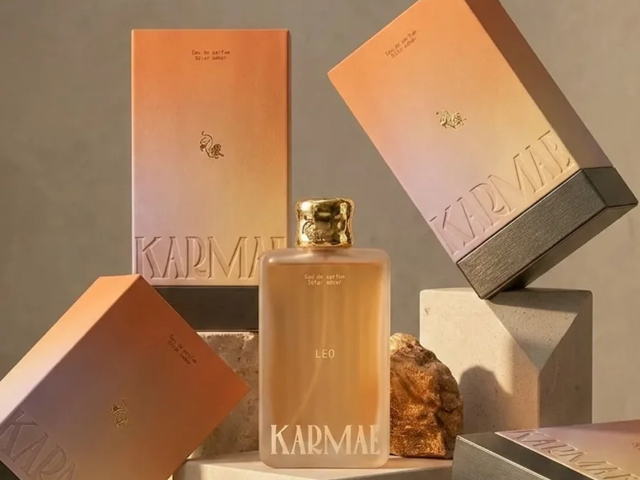 Le flacon Karmae Leo entouré de ses coffrets orange