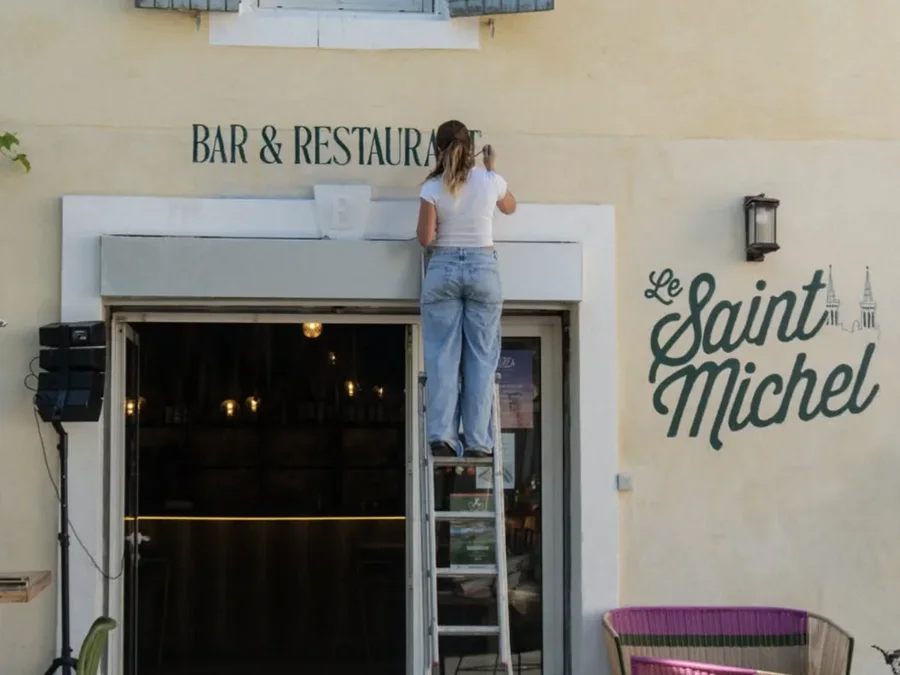 Iona peint « Bar & Restaurant » sur la façade du Saint Michel