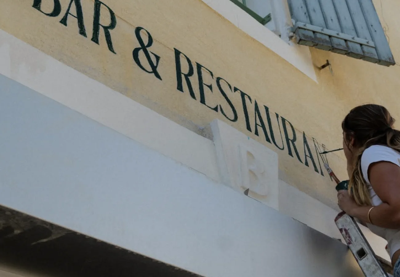 Gros plan sur le lettrage vert « Bar & Restaurant » en cours de peinture